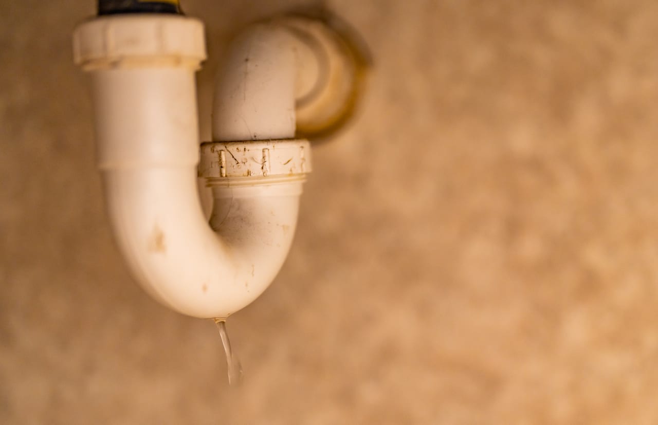 A drop escaping a leaking sink drain trap